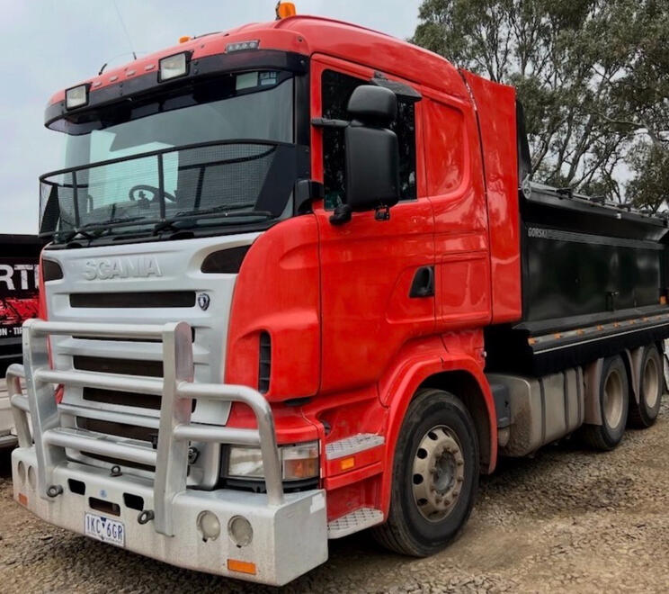 Front view of a red tipper truck used for construction transport.